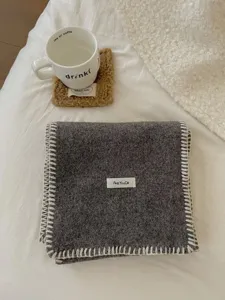 Detalle de bufanda de punto gris acogedora de invierno con bordes blancos de contraste.