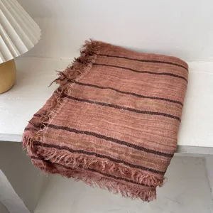 Détail en gros plan d'écharpe rayée à franges rétro, tissu vintage texturé et chaleureux.