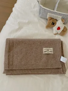 Solid color knitted woolen winter warm scarf with brand label detail, cozy soft wear.