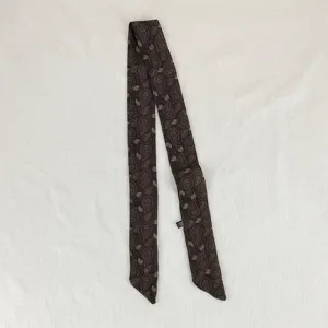 Primo piano del foulard in seta sottile con stampa paisley vintage e dettagli retrò.