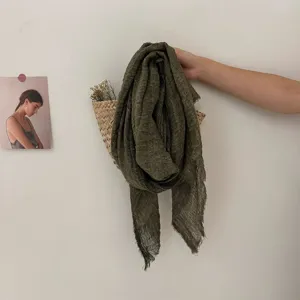 Vue détaillée du foulard texturé vert olive vintage vieilli aux bords frangés pour femme.