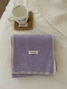 Cálida bufanda de punto violeta con costuras blancas en los bordes para el invierno.