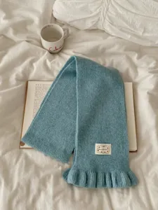 Blue knit scarf detail, cozy ruffles texture, soft winter warm accessory lifestyle shot.