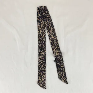 Dettaglio foulard sottile con stampa leopardata, elegante sciarpa stretta per collo o capelli.