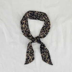 Dettaglio foulard sottile maculato di seta, nastro per capelli alla moda e vista vintage.