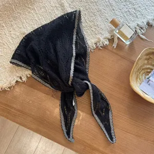 Detailed view of black knitted hollow triangle scarf with contrast gray border for stylish neckwear.