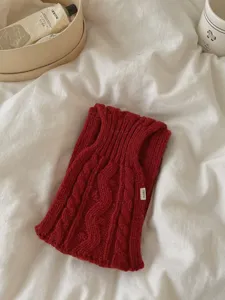 Écharpe tricotée unie à grosses côtes rétro, détail de mode automnale confortable et chic.