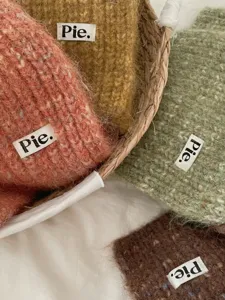 Close-up detailed view of cozy multi-colored knit winter scarf texture in woven basket.