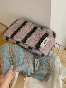 Detail view of cozy winter striped knitted scarf, soft fuzzy material, warm neck accessory.