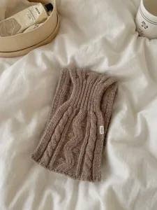 Detail d'echarpe en grossière maille marron, texture douce pour tenues d'automne et d'hiver.