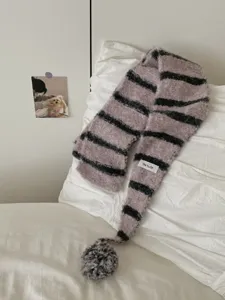 Cozy striped knitted scarf detail with soft fuzzy texture and cute pom-pom decoration.