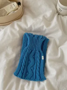 Gros plan sur l'écharpe en tricot torsadé bleu avec motif texturé et style d'hiver confortable.