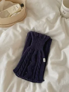 Vue détaillée d'une écharpe en tricot côtelé bleu foncé avec une texture douce et étiquette.