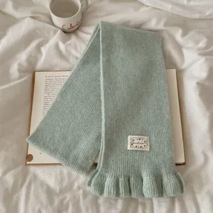 Women winter warm knitted scarf with ruffles, aesthetic soft pastel green neck accessory.