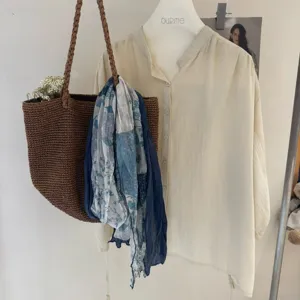 Vista dettagliata della sciarpa in cotone e lino con motivi blu, accessorio elegante e versatile.