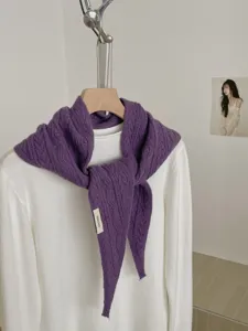 Detailansicht eines lila gestrickten Dreiecks-Schals auf einem Buegel, Herbst Winter.