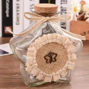 Star shaped glass wishing bottle with cork stopper, rustic jute bow and lace decoration for gifts.