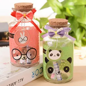 Cute glass wishing bottle with cork stopper, ribbon bow and cartoon tags for birthday gift.