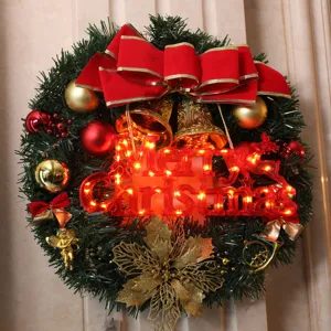 Christmas wreath decoration with LED lights, red bow and golden bells for holiday party.
