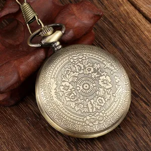 Vintage bronze quartz pocket watch with intricate floral engraving and chain, detail view.