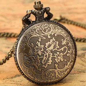 Close-up detail of vintage bronze pocket watch with intricate floral engraving and chain.