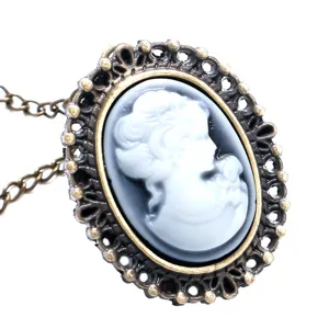 Gedetailleerde close-up van vintage kamee ketting met sierlijke bronzen filigraan montuur.