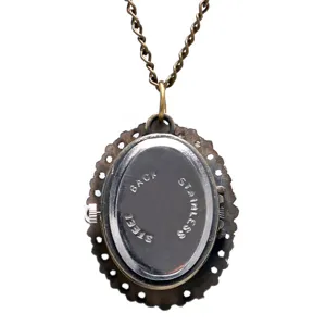 Vintage brons zakhorloge ketting detail met roestvrijstalen achterkant en sierlijke sierrand eromheen.