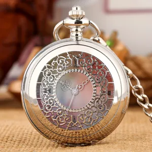 Detailed shot of a vintage silver pocket watch with hollow floral pattern and colorful dial.