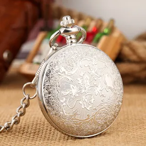 Vintage silver pocket watch with intricate floral engraved case and matching chain.
