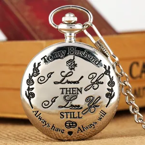 Close-up detail van zilveren zakhorloge met gegraveerd liefdescitaat en prachtig bloemmotief.
