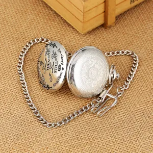 Detail opname van vintage kwarts zakhorloge met gegraveerde liefdesboodschap en ketting.