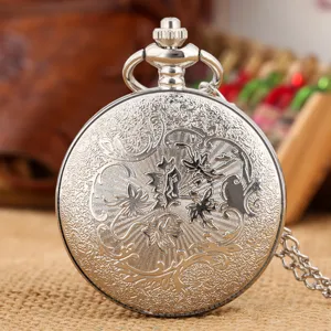 Vintage silver pocket watch with intricate engraved floral pattern and matching chain, detail view.