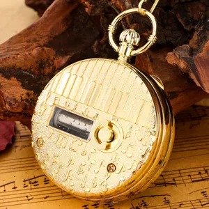 Vintage golden pocket watch with piano keys design and music box movement for music lovers.