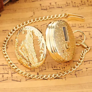 Detailed shot of a vintage gold pocket watch with hollow steam train cover and music note relief.
