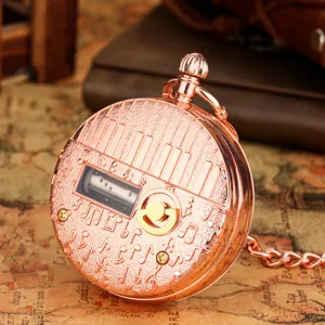 Vintage rose gold pocket watch music box with piano keys engraving, detailed mechanical gear view.