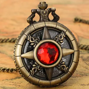 Vintage bronze pocket watch detail shot with red gemstone and Roman numeral dial.