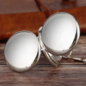 Close-up view of silver polished double open cover mechanical pocket watch with metal chain.