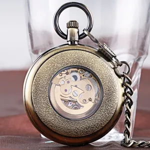 Vintage bronze mechanical pocket watch detail, skeleton gear design with matching chain.