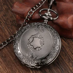 Close-up of a vintage gunmetal pocket watch featuring intricate engraved details and matching chain.