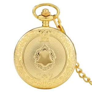 Close-up detail of vintage gold carved pocket watch with intricate floral patterns and blank shield.