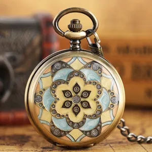 Vintage bronze mechanical pocket watch with green enamel flower pattern and chain accessory.