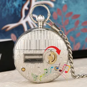 Close-up detail of silver vintage music pocket watch with piano keys and musical notes design.
