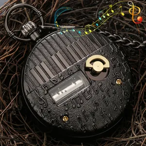 Vintage black piano music box pocket watch detail with intricate musical notes and chain.