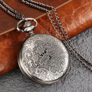 Detail shot of vintage retro quartz pocket watch with intricate floral leaf engraved design and chain.