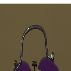 Wecker Metallgriff und Glocke Detailansicht, lila und schwarze Oberfläche, Nahaufnahme.