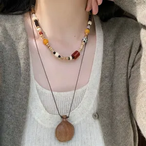 Layered wooden bead and natural stone necklace set, vintage style jewelry detail view.