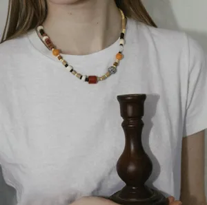 Detail view of the asymmetric colorful beaded necklace, featuring natural stone and wood beads.