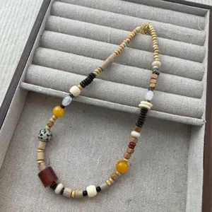 Detail view of asymmetric colorful beaded necklace with natural jade, wood and stone beads.