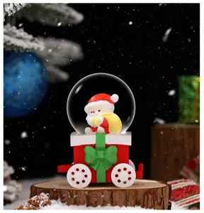 Nahaufnahme Detail der niedlichen Weihnachtsschneekugel mit Santa auf einer Holzeisenbahn.