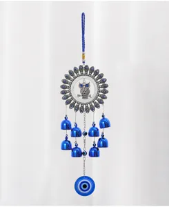Primo piano dettagliato del campanello a vento a forma di gufo con perle blu e campanelli.